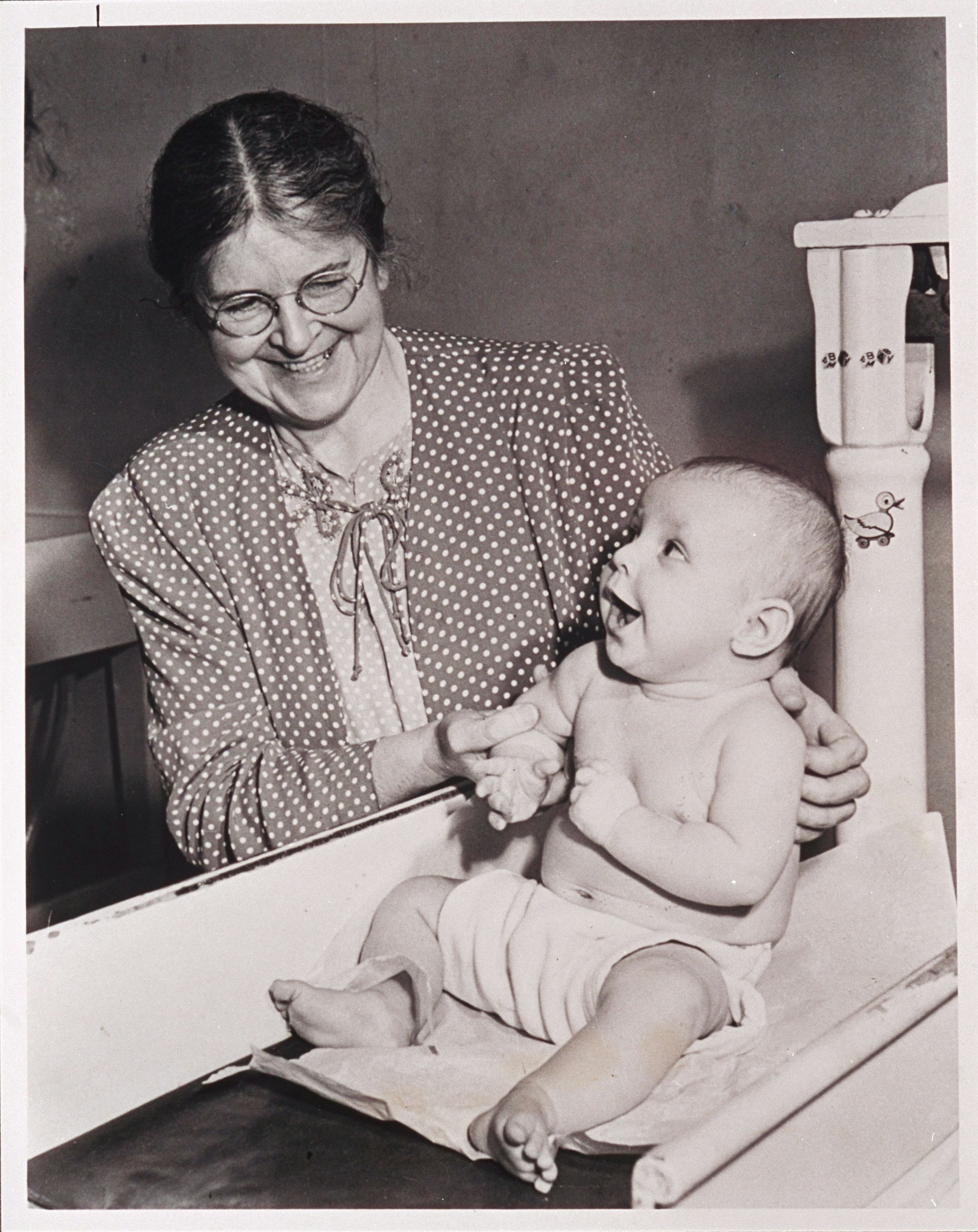 Martha May Eliot holding a child
