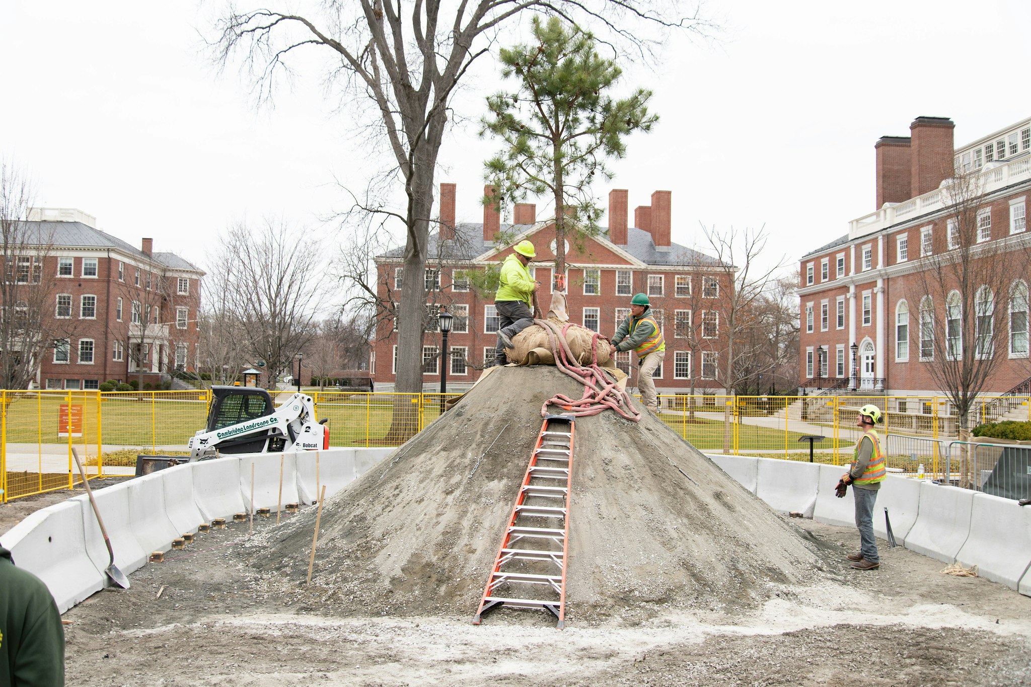 Three construction workers working on mound of sand