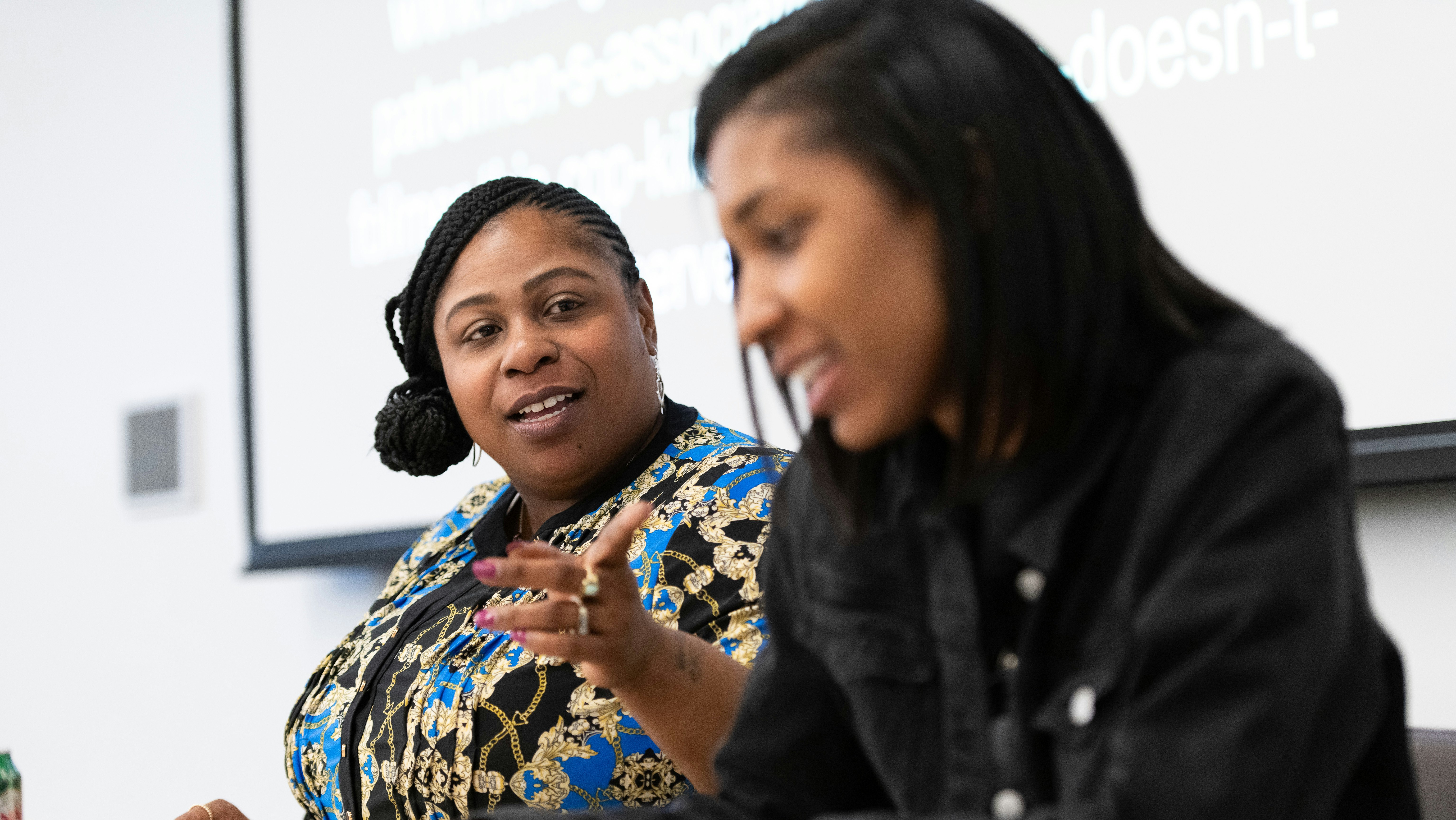 Two women speak on a panel.