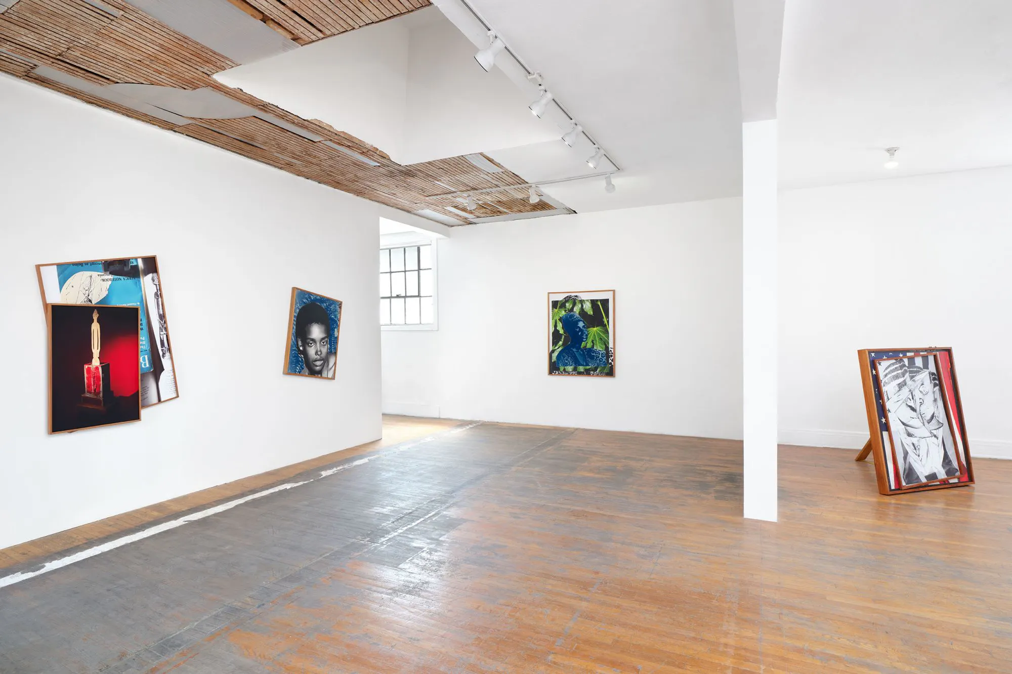 Four large artworks eclectically on display in a large wite gallery with wood-vaulted ceilings.