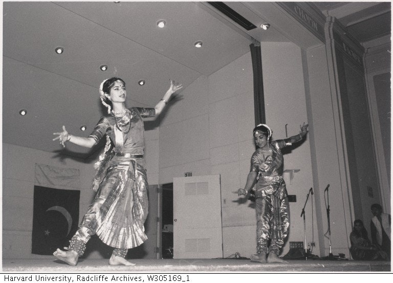 Two women on stage performing Bharatanatyam dance