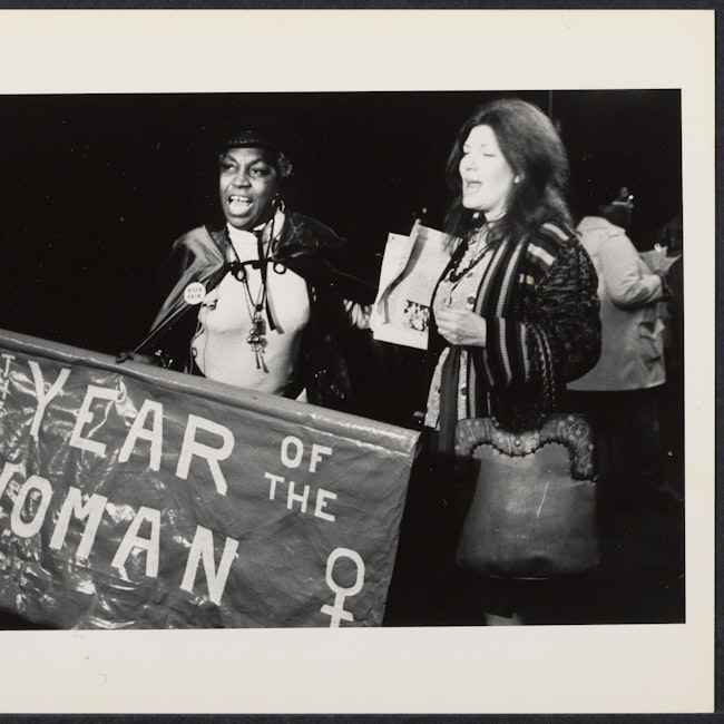 Banner states, "Year of the Woman" with Flo Kennedy and an unidentified woman