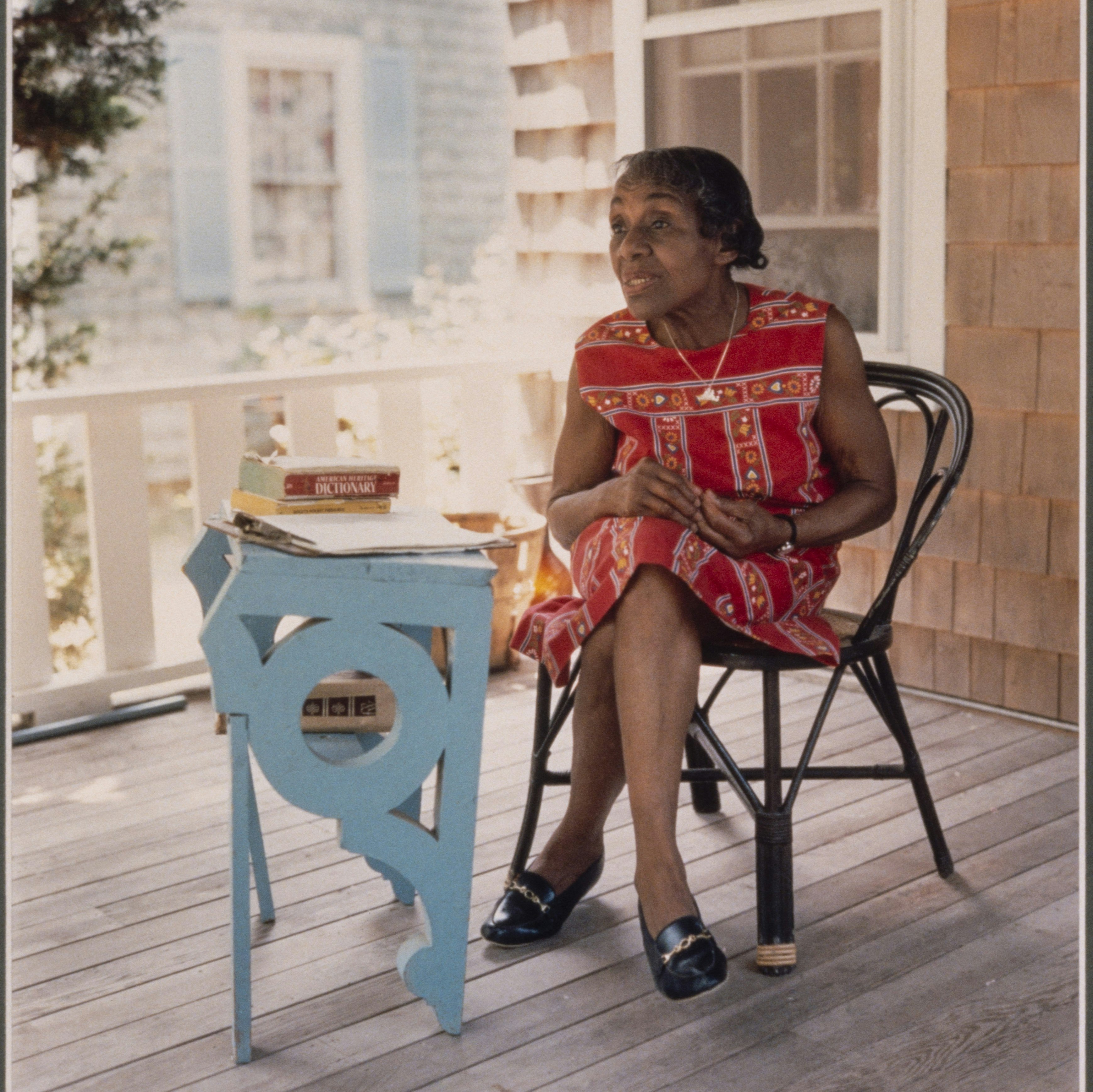 Portrait of Dorothy West, seated in chair on a deck