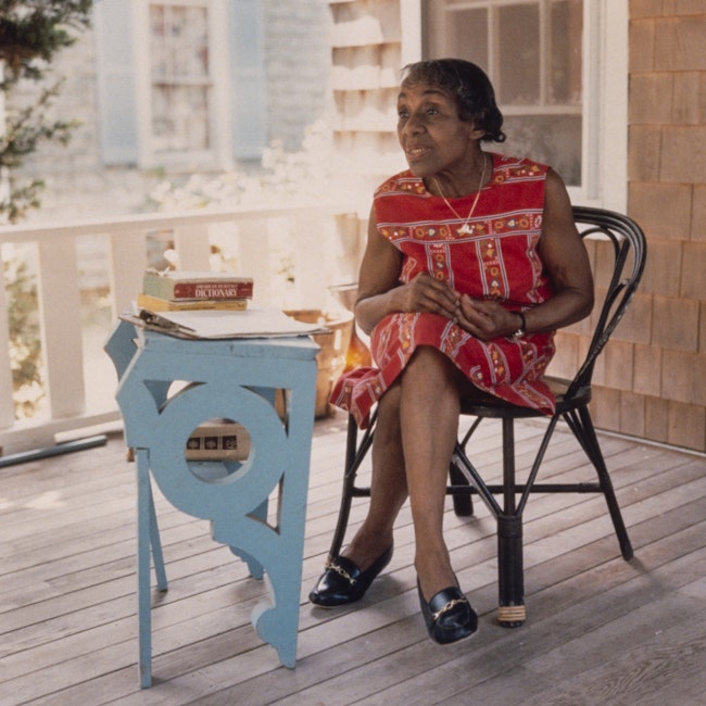 Portrait of Dorothy West, seated in chair on a deck