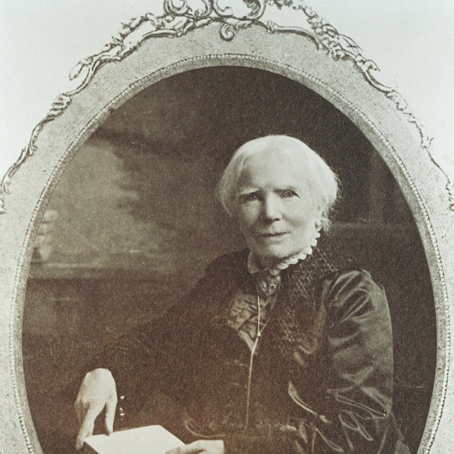 Elizabeth Blackwell seated with an open book on her lap