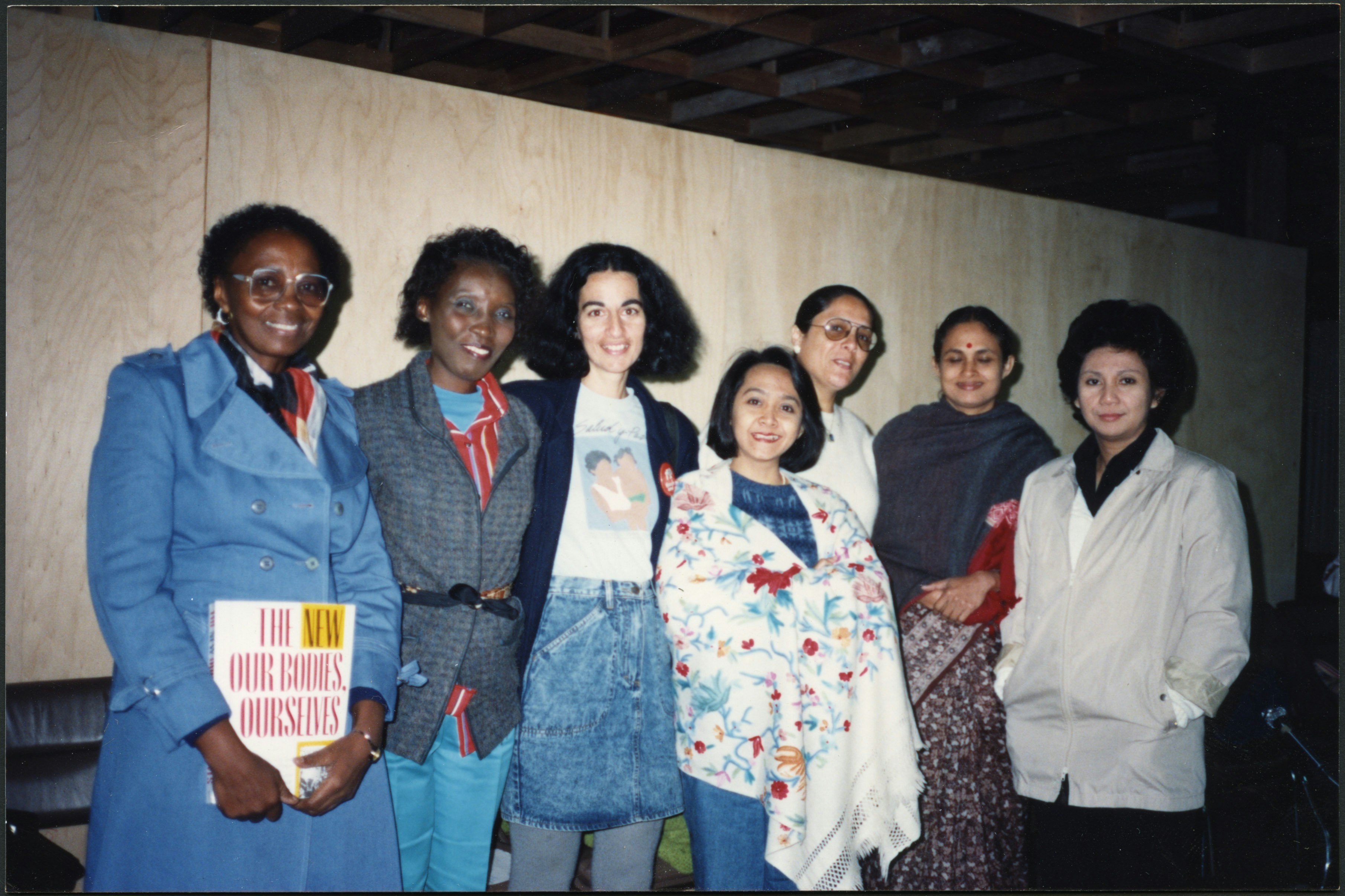 Group of women at International Women's Health Coalition (IWHC)/World Health Organization meeting, holding a copy of The New Our Bodies, Ourselves