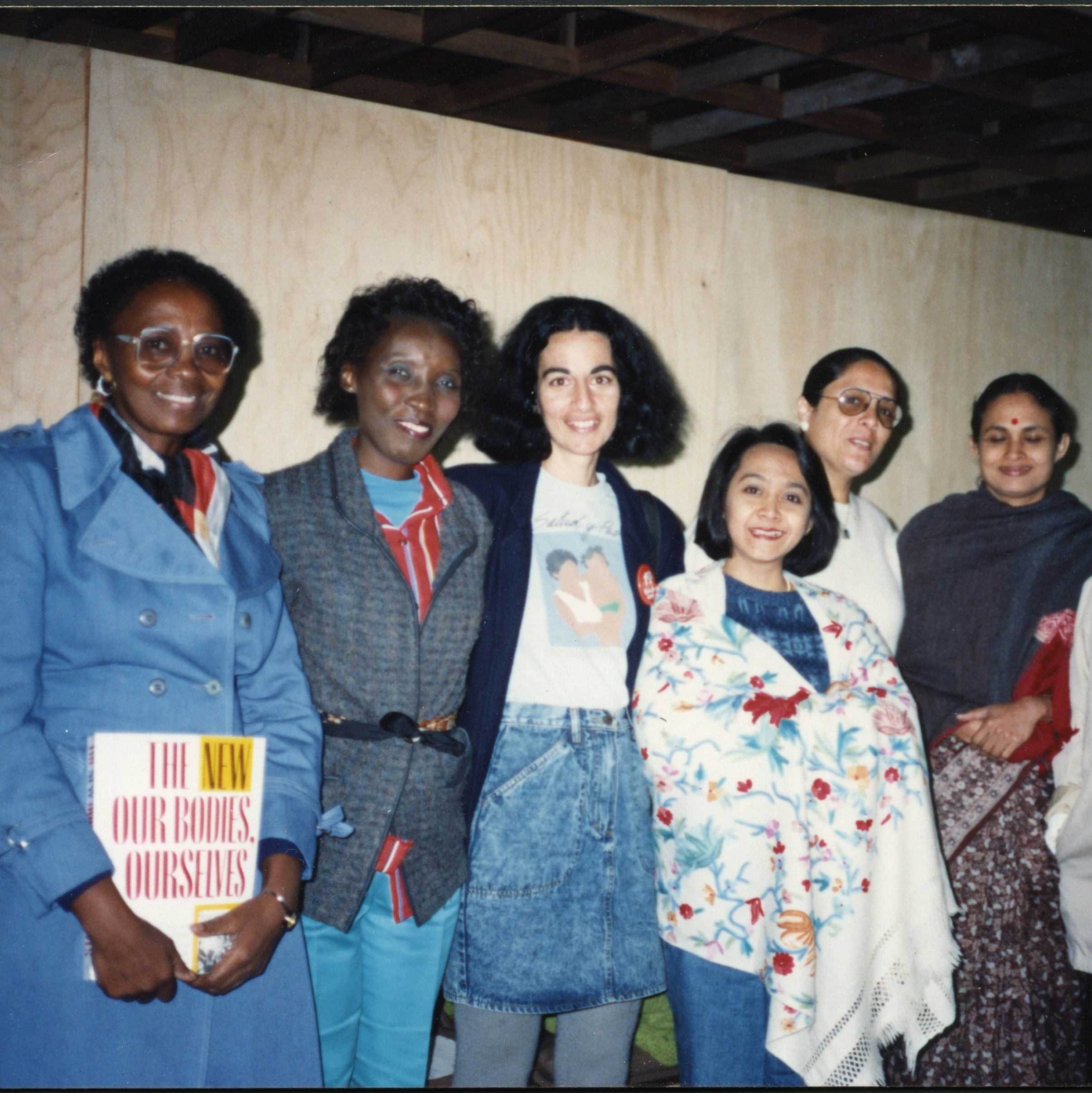 Group of women at International Women's Health Coalition (IWHC)/World Health Organization meeting, holding a copy of The New Our Bodies, Ourselves