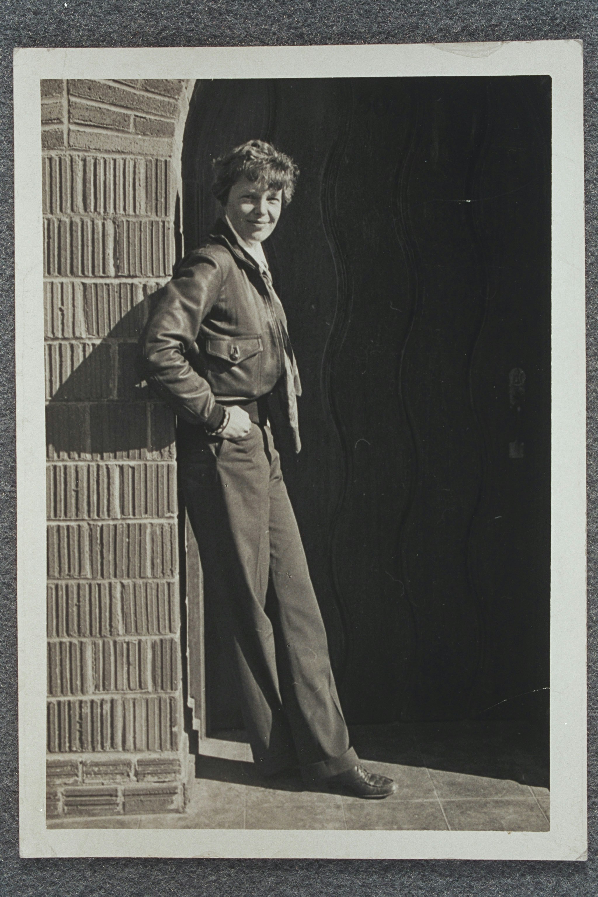 Amelia Earhart leaning against a wall