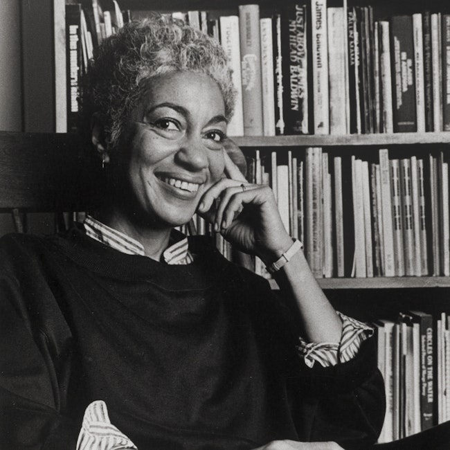 June Jordan seated in front of bookcase