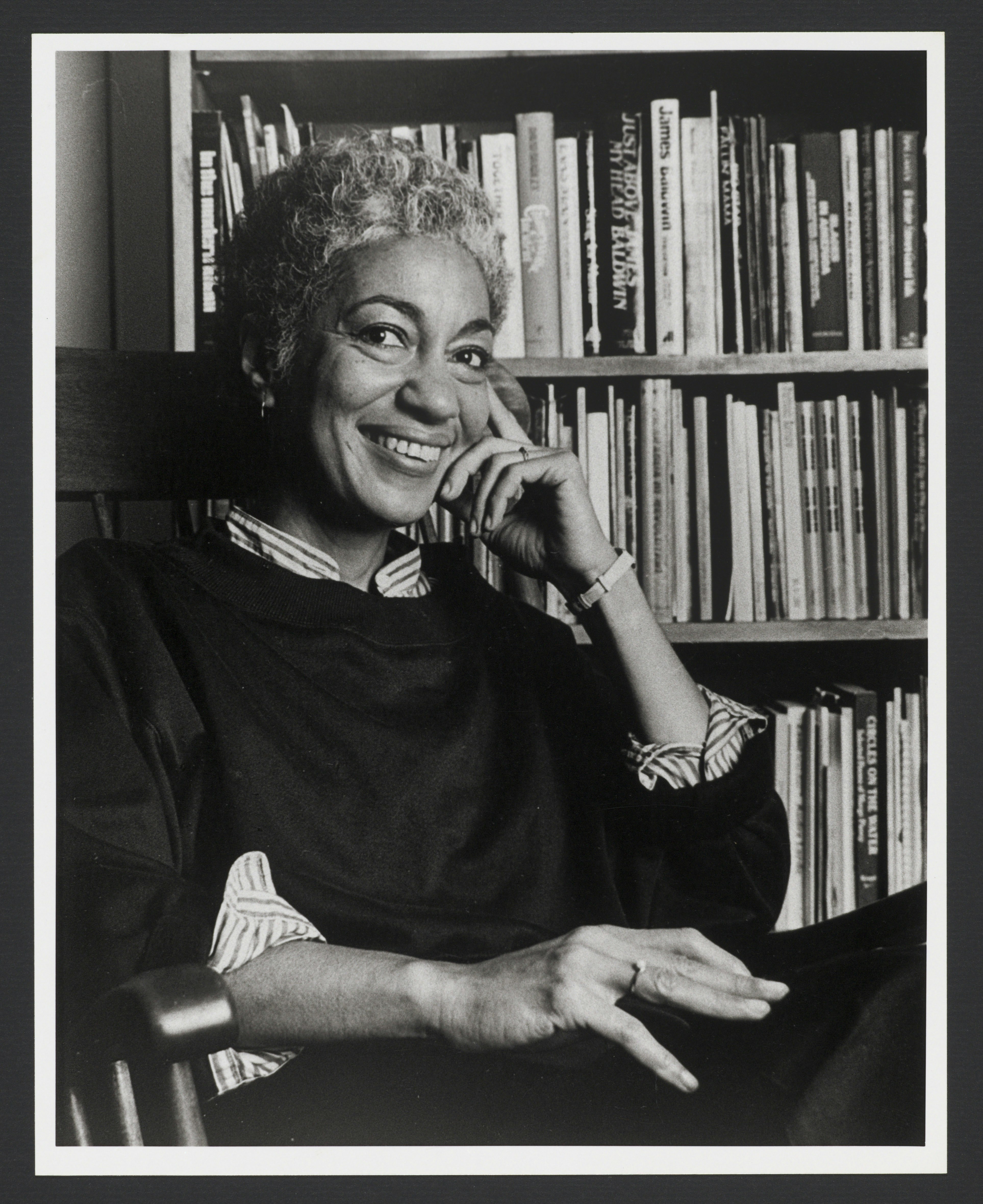 June Jordan seated in front of bookcase