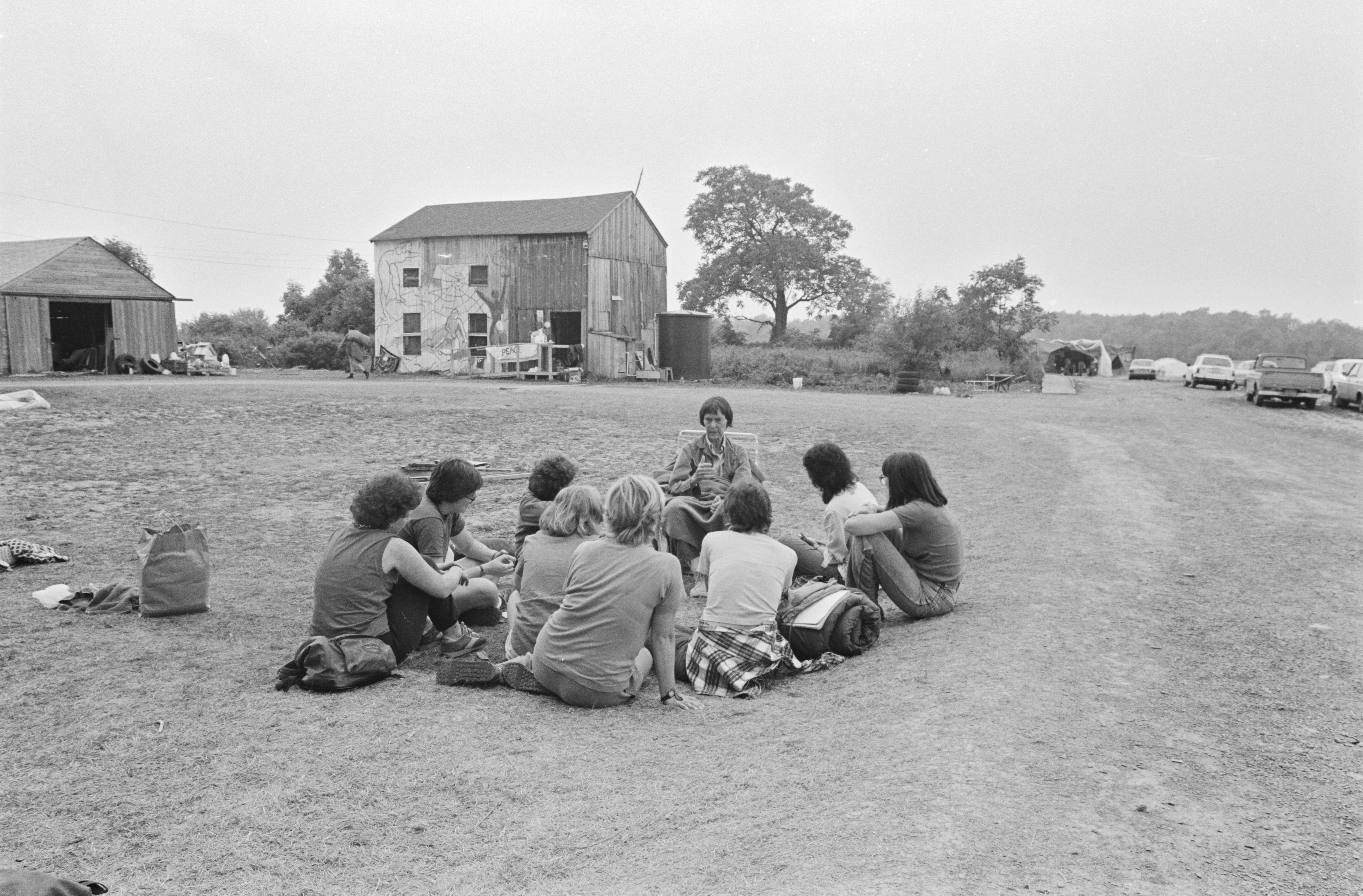 Barbara Deming with a circle of women seated on the ground