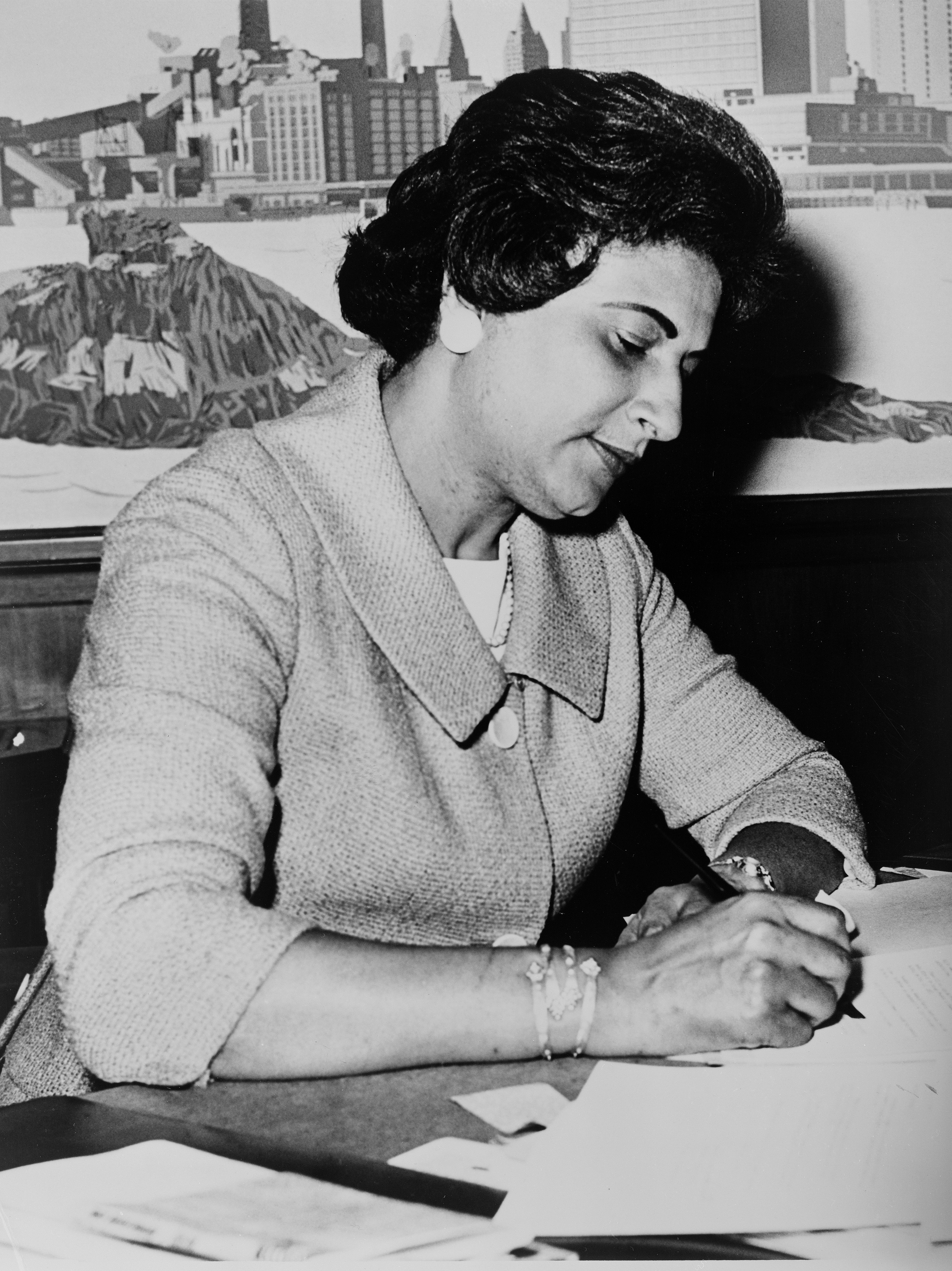 A black-and-white photo of Constance Baker Motley sitting at a desk, doing paperwork