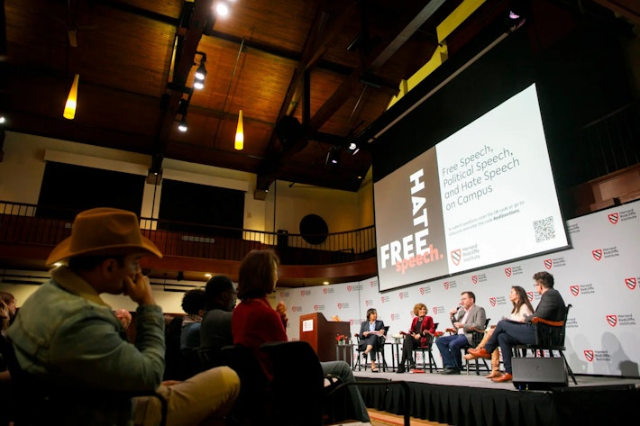 Five people sit in chairs on a stage in the Knafel Center at Harvard Radcliffe Institute