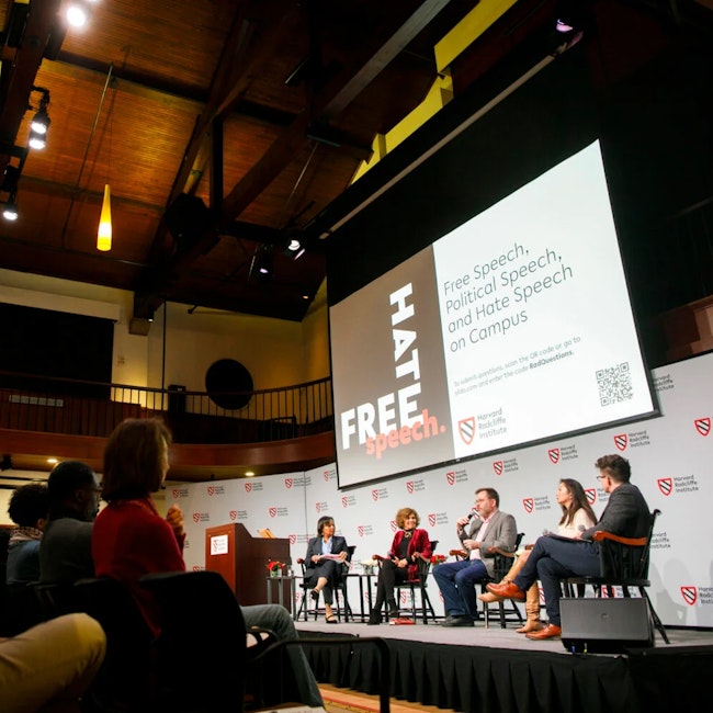 Five people sit in chairs on a stage in the Knafel Center at Harvard Radcliffe Institute