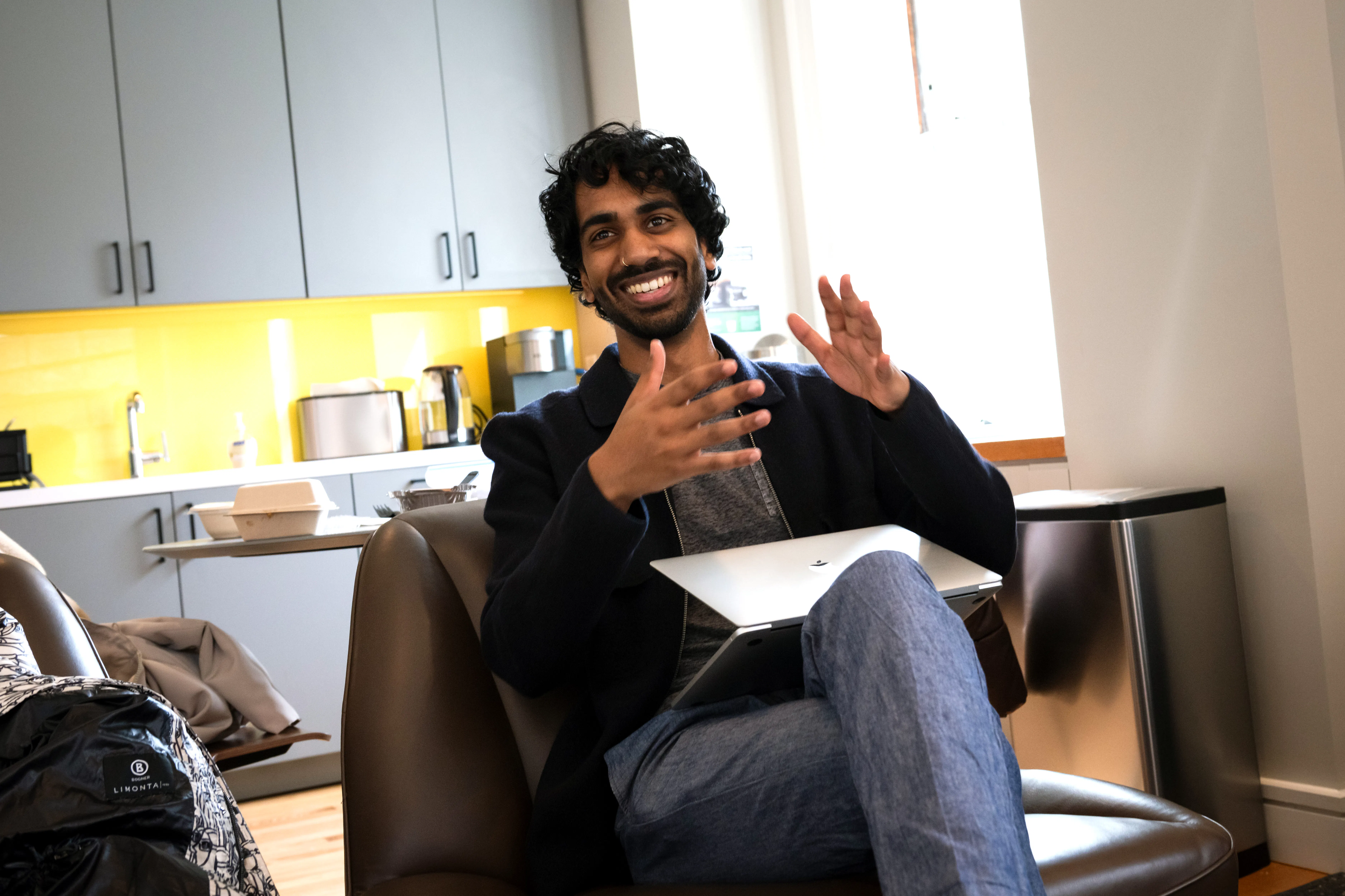 Saman de Silva smiling and gesturing with his hands.