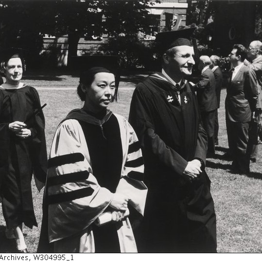 Professor Rulan Chao Pian walking in graduation cap and gown