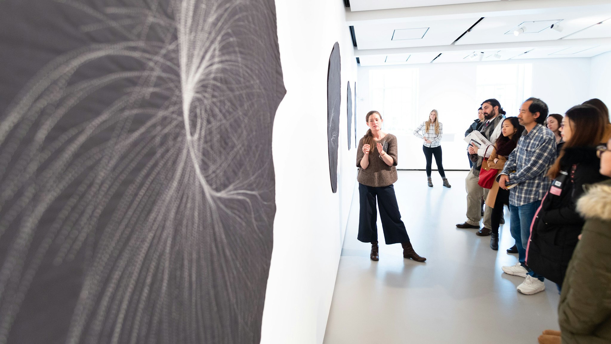 A group gathered admiring art at the 2018 Harvard Gallery Crawl.