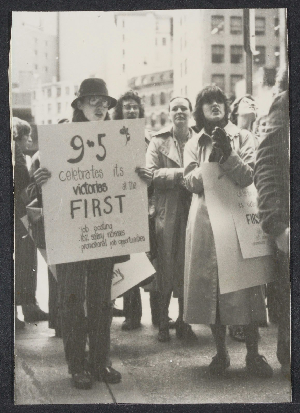 Group of people holding posters at the First National Bank rally