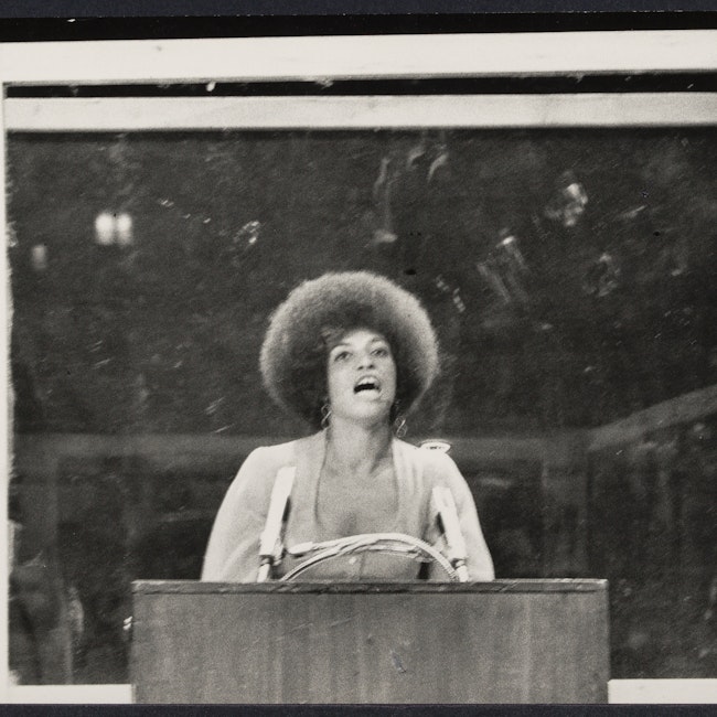 Bullet proof cage surrounds Angela Davis as she performs in "Night with Angela Davis" at Madison Square Garden