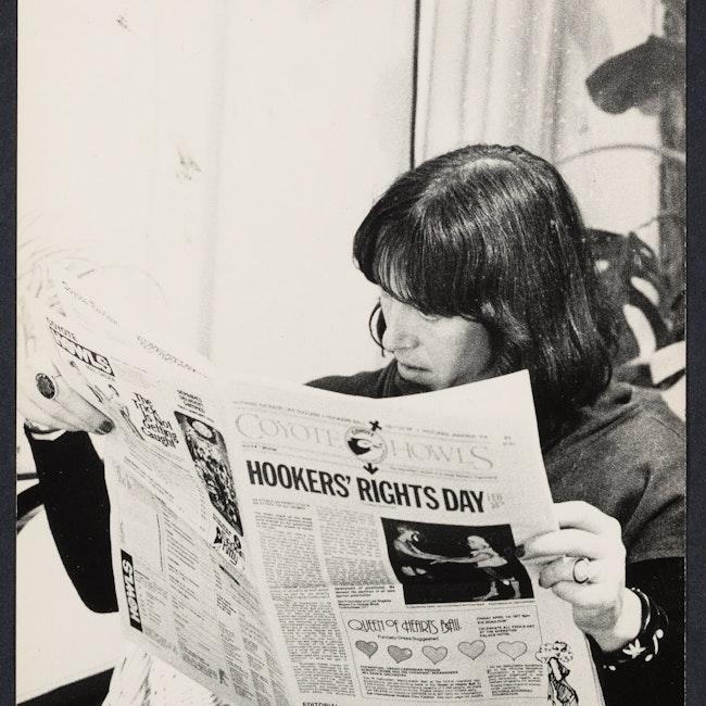 Margo St. James reading a newspaper at the Battered Women's conference