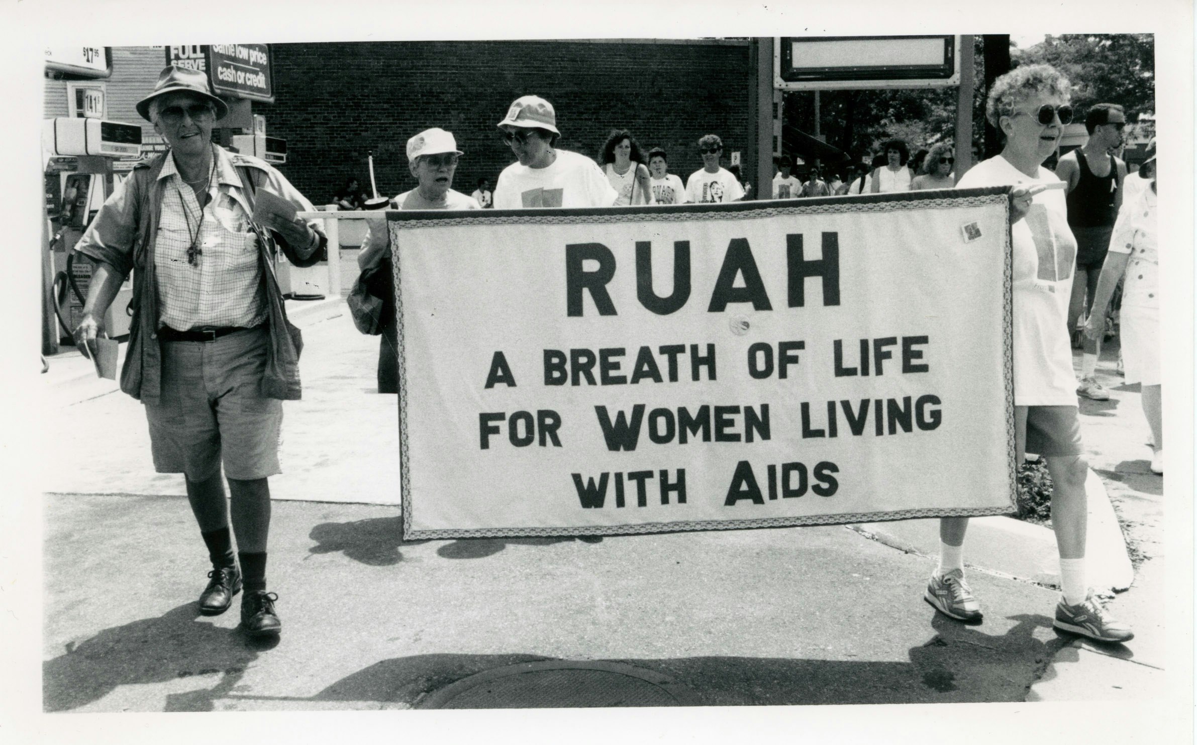Kip Tiernan and Sr. Jeanette marching with Ruah (interfaith organization) banner. Text reads "A breath of life for women living with AIDS", 1991