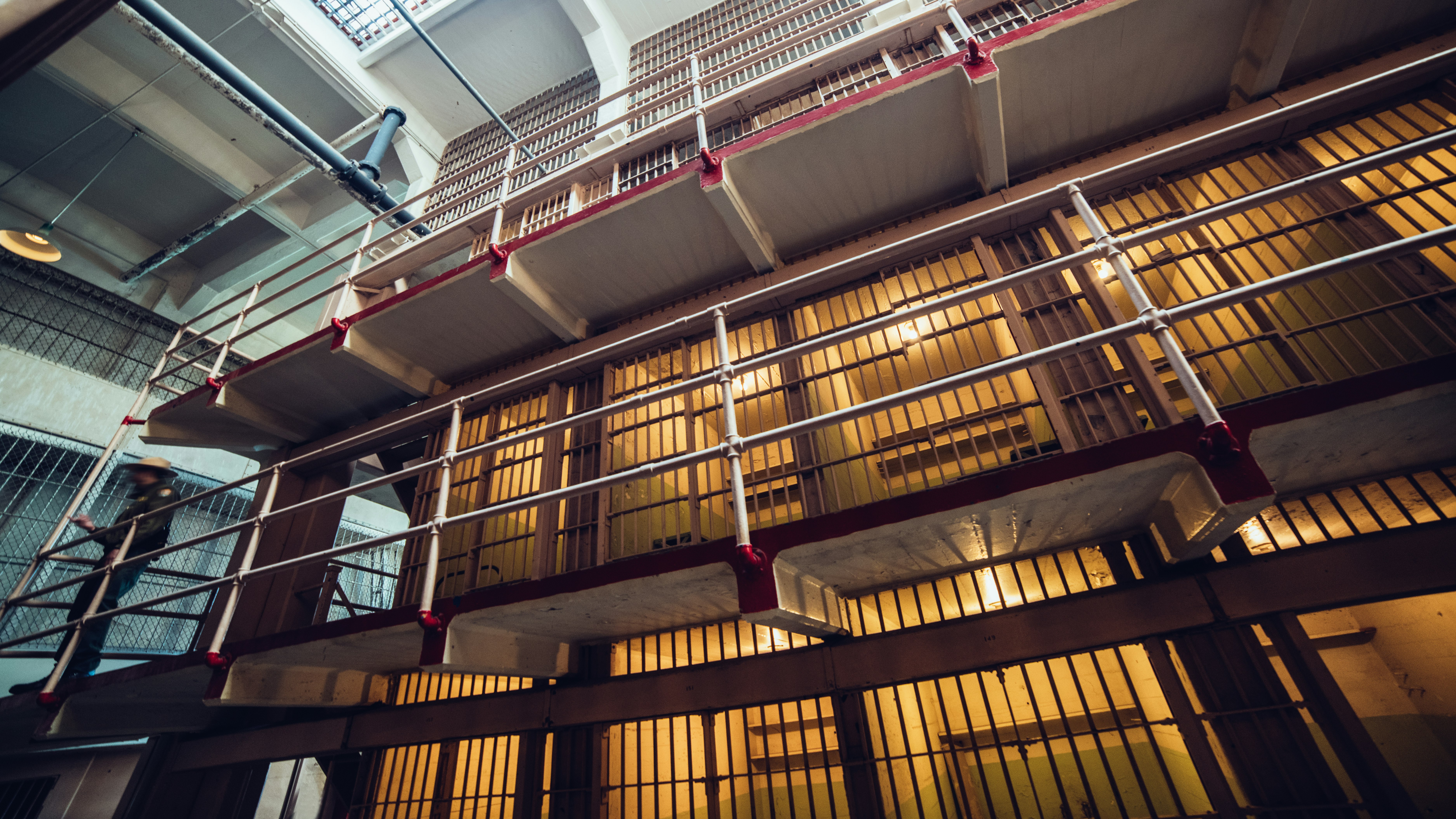 A look inside a large, three-story prison. A guard perches outside the cells on the second level.