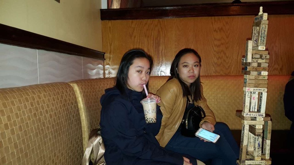 Vanessa Hu and friend sipping bubble tea and playing Jenga