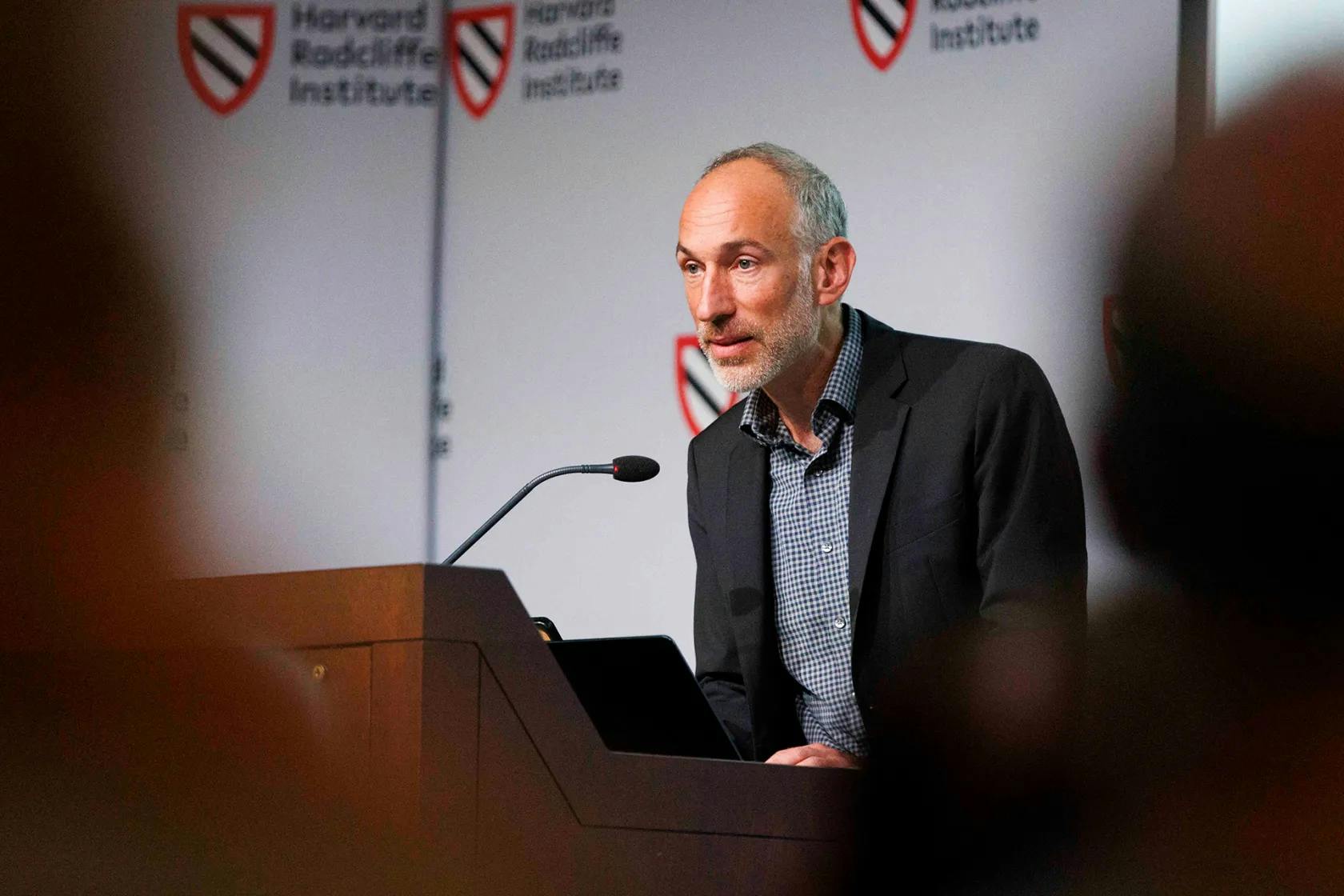 A man speaks into a microphone at a podium