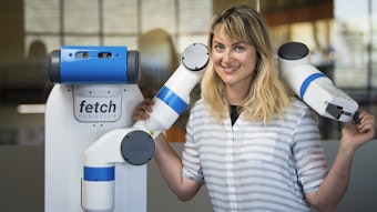 Heather Knight posing with robot's arm around her shoulders.