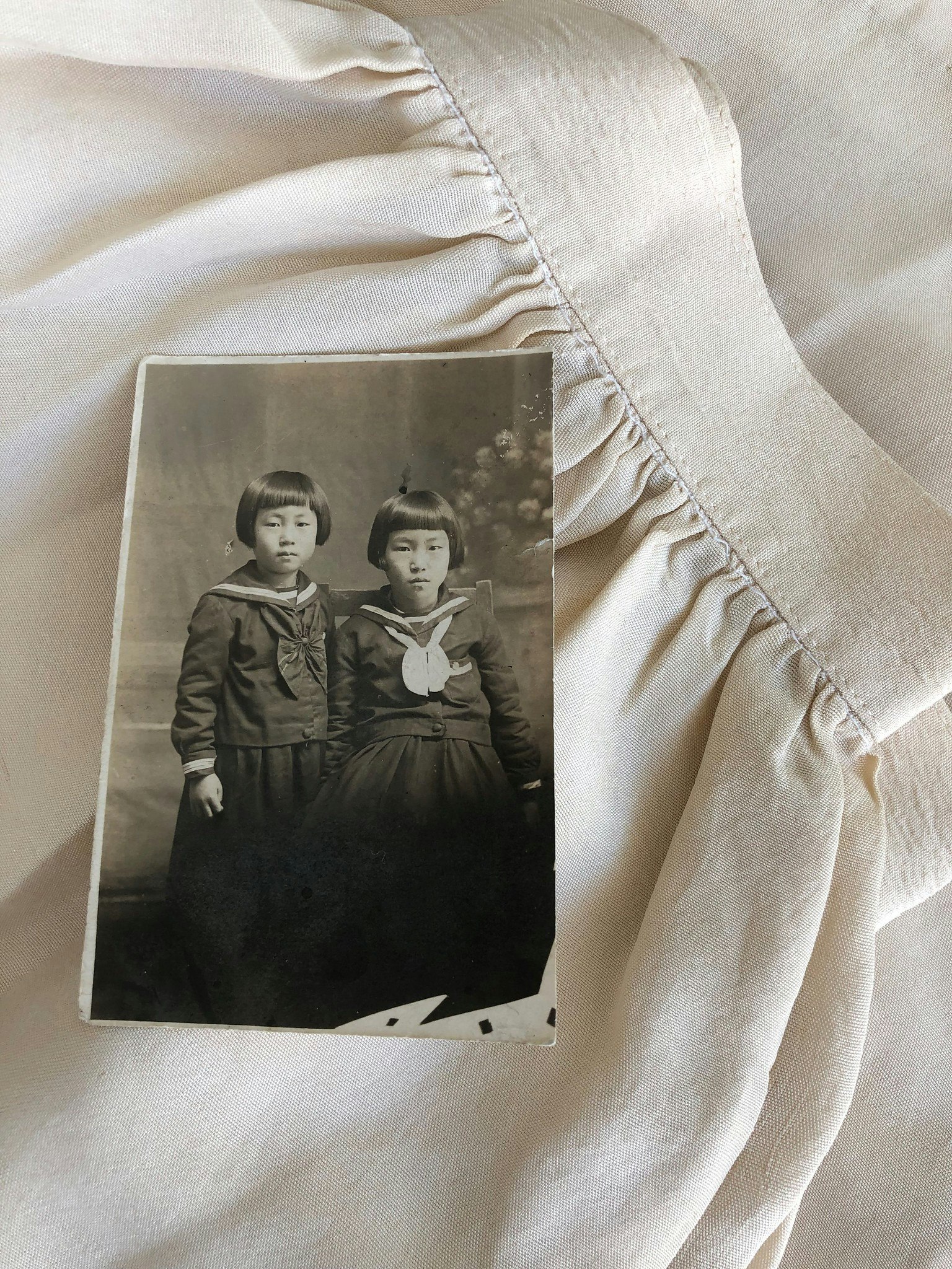 Sepia toned photo of Jeannie Park's mother and aunt. Photo rests on a skirt from handmade silk