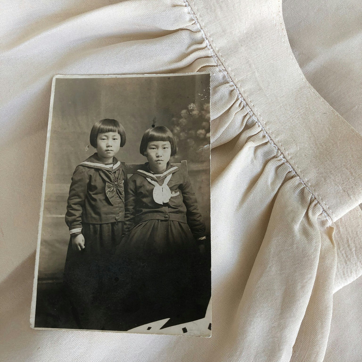 Sepia toned photo of Jeannie Park's mother and aunt. Photo rests on a skirt from handmade silk