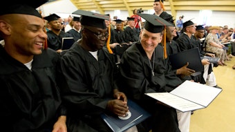 Students sitting together in graduation caps and gowns