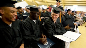 Students sitting together in graduation caps and gowns