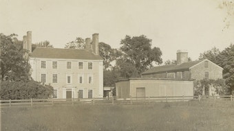 A sepia-toned photo of a mansion and slave quarters, in Medford, Massachusetts.